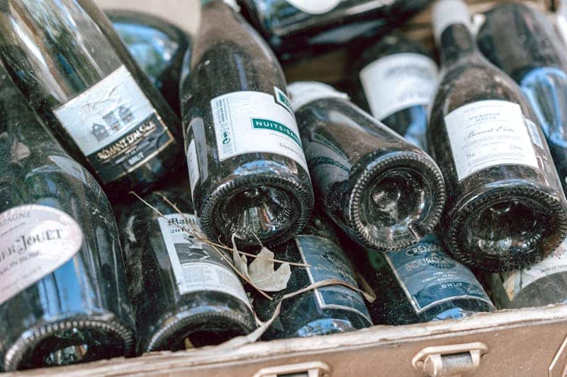 Bouteilles de vin anciennes et entassées prêtent à être nettoyé par une laveuse professionnelle de chez Aquatech BM